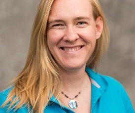 picture of woman in turquoise shirt with gray background
